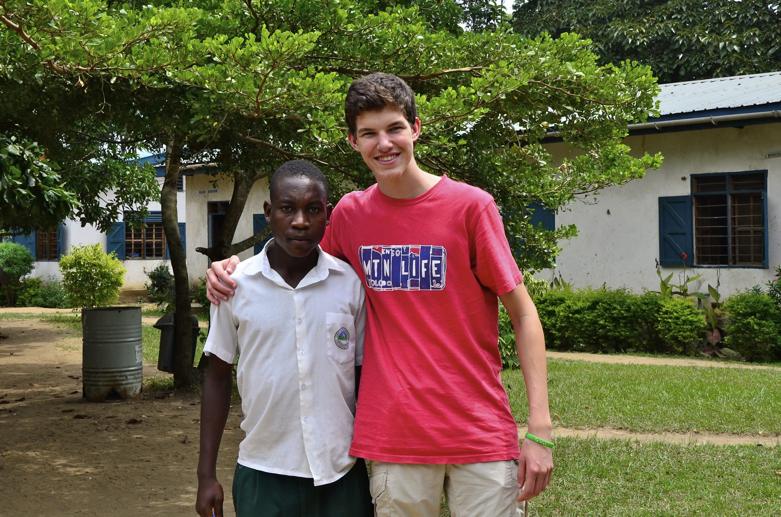 Young teen man hugs African man